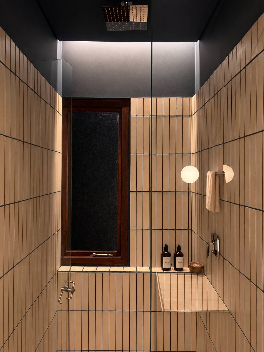 Ducha en cerámica beige con techo negro de la Suite Cerros apartamento 202