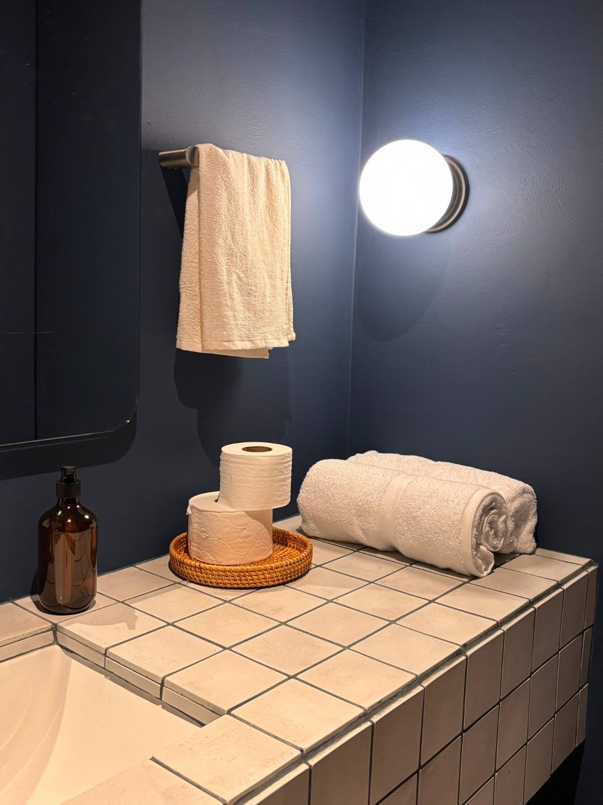 Baño en azul profundo con toallas y amenidades de la Suite Cerros 202