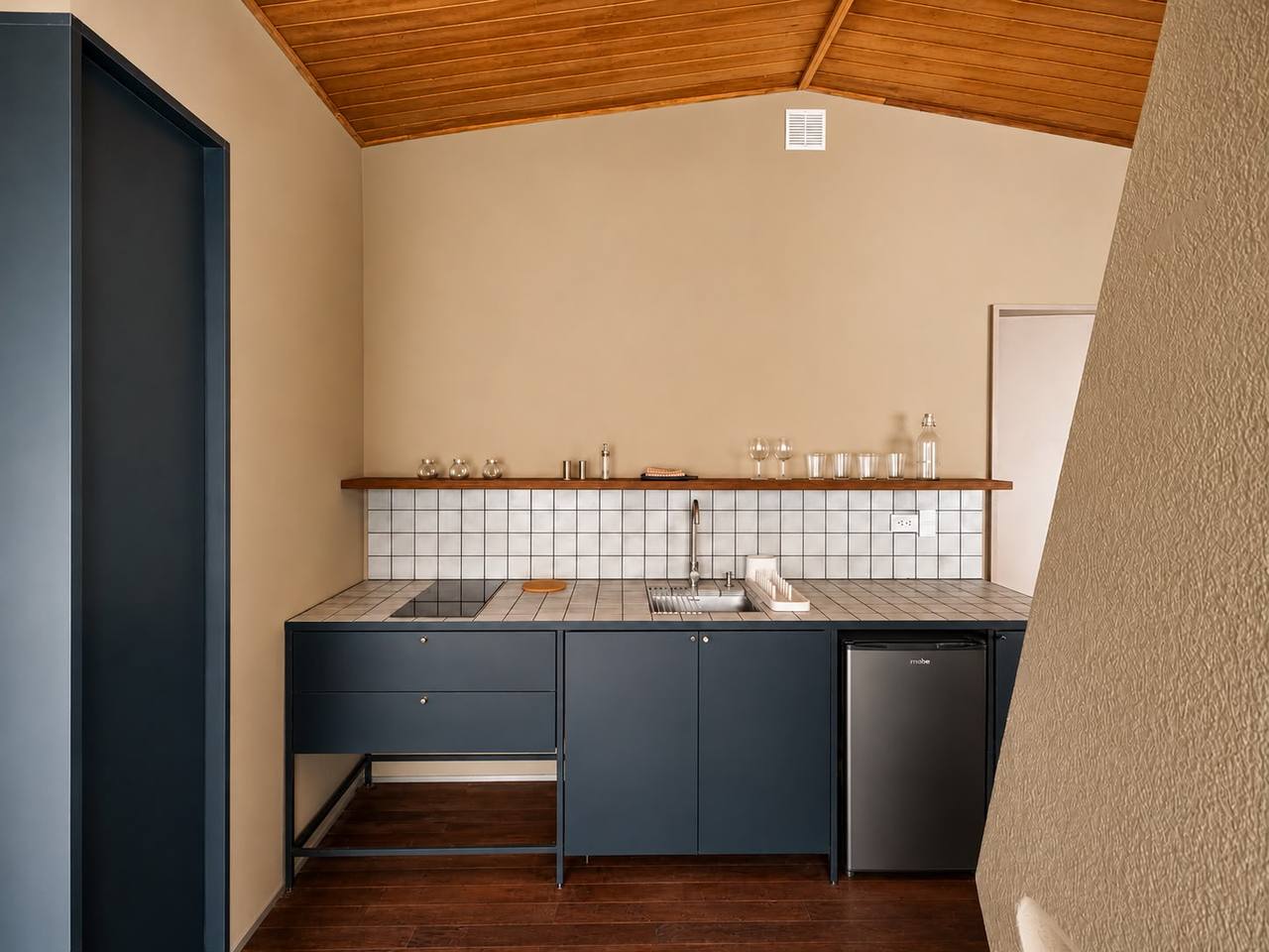 Cocina azul profundo con enchape blanco de la Suite Cerros apartamento 202